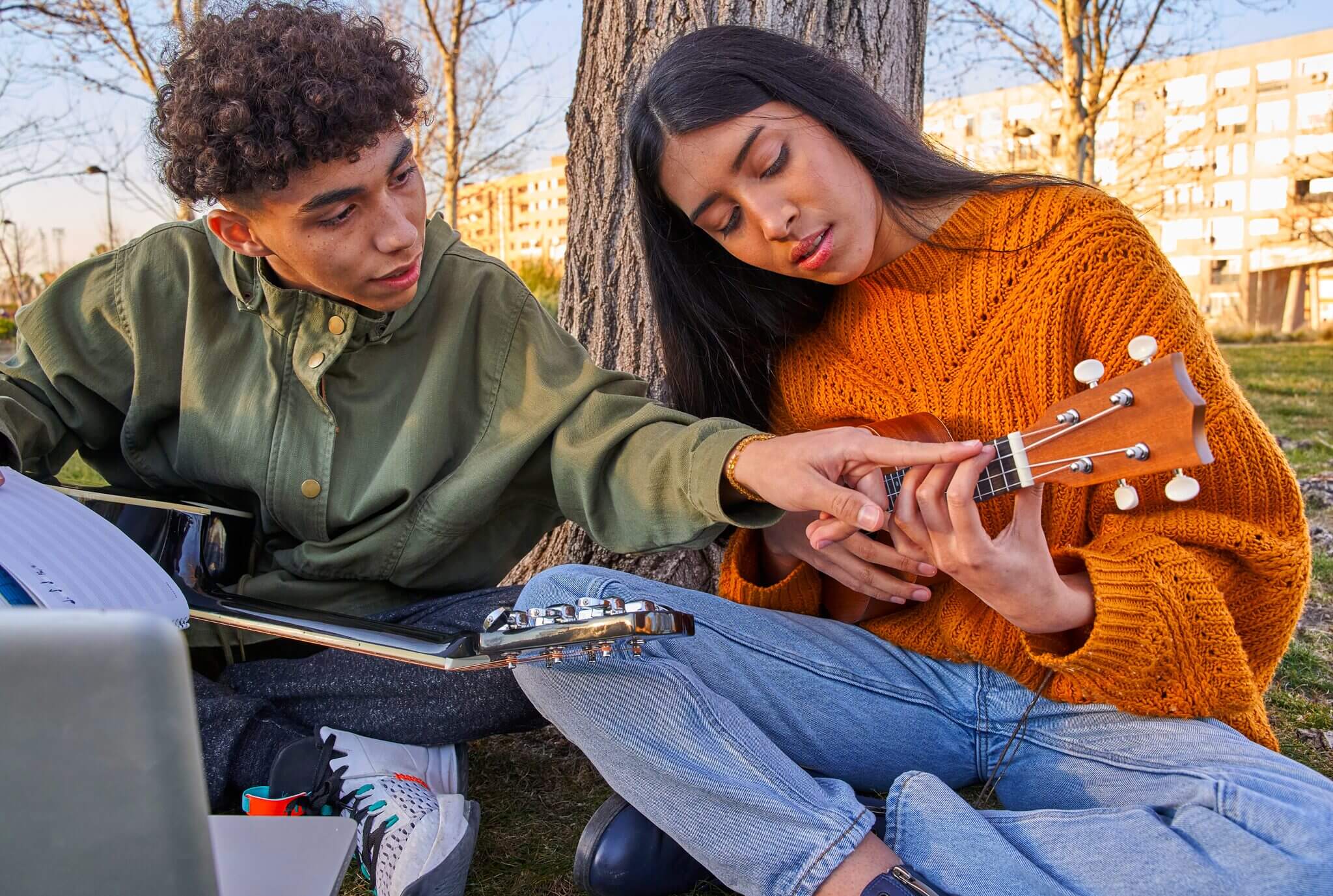 Two students playing music in their online class.